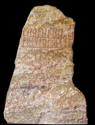 Stele mit Runeninschriften, die einen Wikingerreiter mit einem Hund darstellen