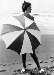 Frau mit Regenschirm am Strand
