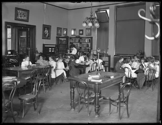 Kinder lesen im Lesesaal einer nicht identifizierten Filiale der Queens Borough Public Library, ca. 1910