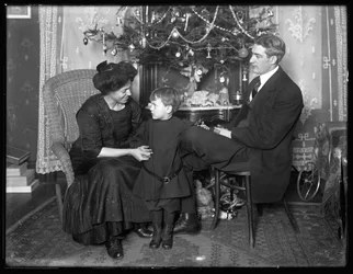 Dan Seymour und Familie in informeller Pose, sitzend unter einem Weihnachtsbaum, Weihnachten 1912