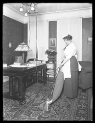 Unbekannte Frau demonstriert die Verwendung des Apex-Staubsaugers, ca. 1913-14